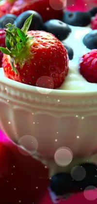 This live wallpaper depicts a white bowl filled with fresh strawberries and blueberries, accompanied by a cup of yogurt on a luxurious velvet tablecloth