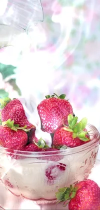 This phone live wallpaper features a picturesque scene of pouring milk into a bowl filled with delicious strawberries