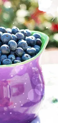 This phone live wallpaper features a lovely purple vase filled with plump blueberries alongside a steaming cup of coffee, set against a cheerful summer day