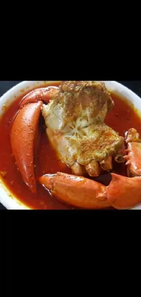 Enjoy a stunning food live wallpaper on your phone with a close-up view of a delicious bowl of soup accompanied by a huge crab