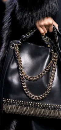 This unique live wallpaper features a close up of a designer handbag with a metal chain against a black cape background