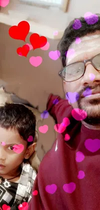 Looking for a heartwarming phone live wallpaper? Check out this image of a man and a little boy sitting on a couch! The man is pictured wearing glasses and a goatee, in a headshot profile picture that's an 8k selfie photograph