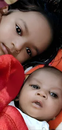 This live wallpaper showcases two children of Assamese ethnicity, snuggled under a warm blanket on a bed