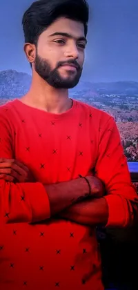 This phone live wallpaper showcases an innocent-looking man standing with his arms crossed, wearing a vibrant red shirt and possessing a reddish beard and hair
