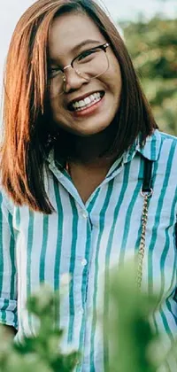 This live wallpaper showcases a woman in a field, beaming at the camera with a stripe shirt