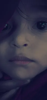 This captivating live wallpaper showcases a close-up of a young child wearing a hoodie and cuddled up in a warm blanket