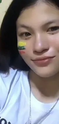 This live phone wallpaper showcases a vibrant image of a woman with a national flag painted on her face, complemented by body spikes for a unique touch