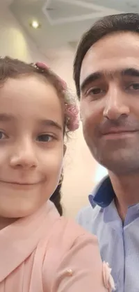This live wallpaper showcases a heartwarming scene of a man and a little girl posing for a picture in an office setting