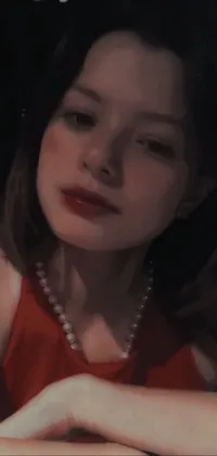 This live wallpaper features a bold and striking image of a woman in a red dress seated at a table