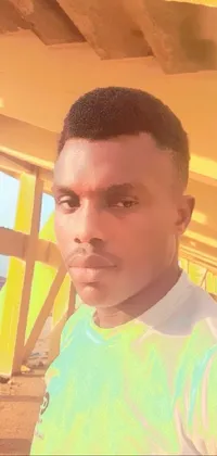 This phone live wallpaper showcases a man standing in front of a yellow building, taking a selfie with a flat top haircut and warm, natural lighting
