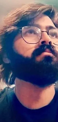 This phone live wallpaper features a breathtaking close-up of a young adult with glasses and a beard
