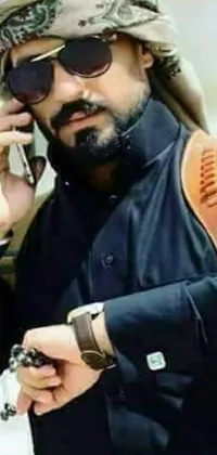 Experience the vibrant energy of a man in a turban effortlessly balancing a cell phone and bolt pistol in this 2019 trending live wallpaper for your phone