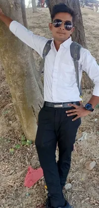 This live wallpaper features a young man in a casual pose standing next to a tree