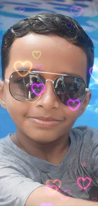 This live wallpaper showcases a young boy taking a selfie in a refreshing pool, with a vibrant and colorful picture filter that gives the image an Instagram feel