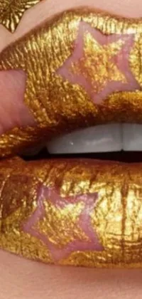 This phone live wallpaper features a striking close-up of lips with golden paint and starry tattoos