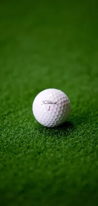 This phone live wallpaper showcases a photorealistic image of a white golf ball on a green field