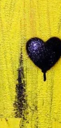 This phone live wallpaper showcases a stunning black heart painting on a bold yellow wall