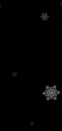 This phone live wallpaper features black and white snow flakes on a sleek black background