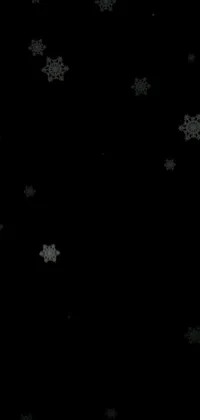 Enhance your phone screen with this enchanting live wallpaper featuring a black and white photograph of intricate snowflakes set against a sleek black background