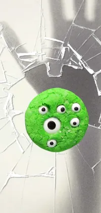 Looking for a unique and quirky phone live wallpaper? Look no further! This design features a green doughnut with googly eyes, peeking out of a broken window