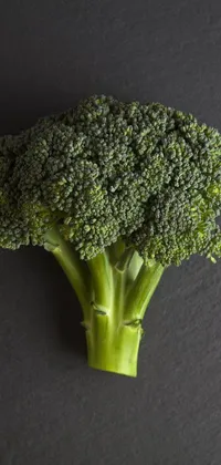 Looking for a unique live wallpaper to beautify your phone's screen? Check out this stunning close-up shot of some fresh, green broccoli set against a neutral background
