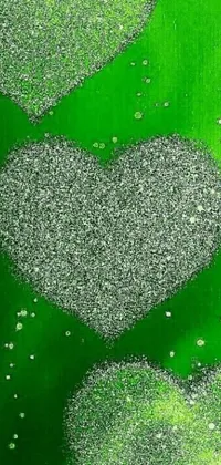 This phone live wallpaper showcases a stunning pointillism painting of two hearts on a green background