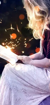 This live wallpaper for your phone features a captivating scene of a woman immersed in a book while sitting on a large rock