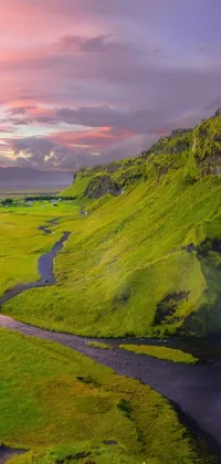 This phone live wallpaper depicts a scenic view of a flowing river through a lush valley, showcasing a picturesque landscape at sunset