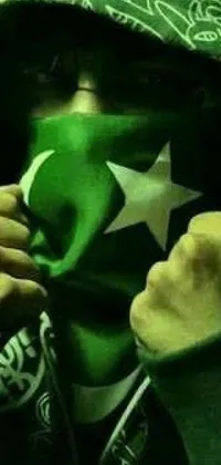 This vibrant phone live wallpaper displays a man wearing a sweatshirt with a painted Pakistan flag on his face