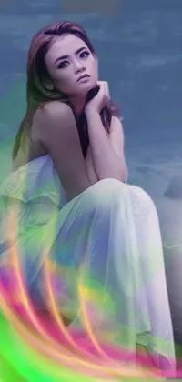 This vibrant live wallpaper features a woman sitting on a sandy beach