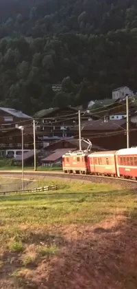 This phone live wallpaper showcases a mesmerizing scene of a red train travelling through lush green hillsides