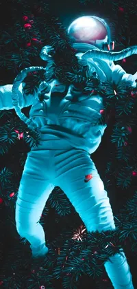 This phone live wallpaper features an astronaut floating in front of a Christmas tree, set against a moody blue background