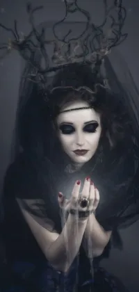 This phone live wallpaper features a stunning Gothic-inspired woman wearing a veil and a crown, with dark makeup and wild hair