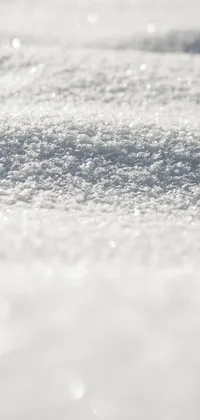 This phone live wallpaper showcases a stunning close-up of a snow-covered ground with a beautiful white pearlescent finish