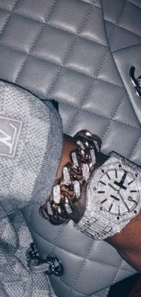 This dynamic phone live wallpaper showcases a stunning close-up of a fashionable watch prominently displayed on a wrist