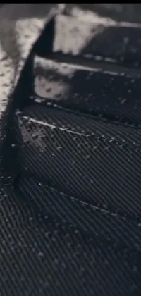 Experience an immersive and visually stunning phone live wallpaper that features a detailed close-up of a piece of luggage with a rain-soaked surface