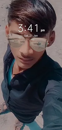This phone live wallpaper features a male teenager taking a selfie on a sunny beach while wearing trendy glasses