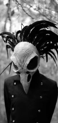This live wallpaper features a black and white gothic image of a person sporting a bird mask, set against a misty forest backdrop with slender trees