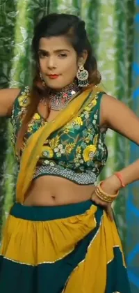 This mobile live wallpaper showcases a beautiful woman dressed in a striking green and yellow sari, elegantly dancing in a colorful scene