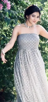 This phone wallpaper showcases the image of a woman wearing a gorgeous strapless dress, against a background colored in grey and silver
