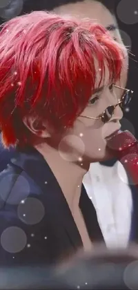 This live wallpaper features a striking image of a woman with vivid red hair, clutching a microphone