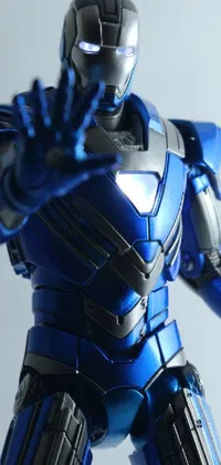 This phone live wallpaper showcases a detailed close-up of a toy Iron Man figurine with a blue and black color scheme in a Shin Hanga art style background