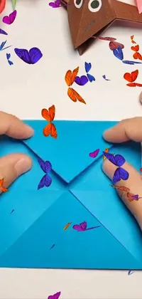 This phone live wallpaper features a close-up image of a child's hands holding a blue envelope