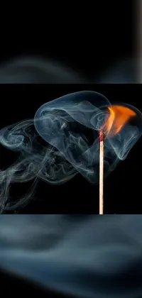 This phone live wallpaper showcases a striking matchstick with smoke lingering from the burnt end