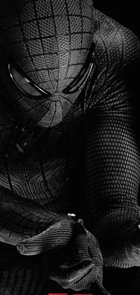 Looking for an intense and striking live wallpaper for your phone? Check out this black and white photo featuring a man in a Spider-Man suit hanging upside down from a silver web! The tight-fitting suit accentuates the man's muscular build, while the shimmering silver strands of the web catch the light