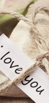 This live wallpaper features a loving message on a piece of paper with rustic burlap