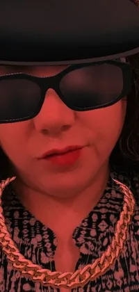 This iPhone live wallpaper showcases a close-up of a fashionable individual donning a hat and sunglasses in an artistic style