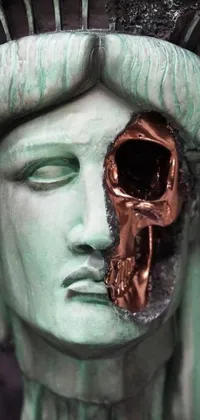 This phone live wallpaper features a close up of a sculpture depicting the Statue of Liberty with a skull, surrounded by broken statues