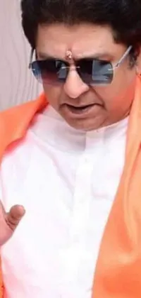 This phone live wallpaper features a close-up of a person wearing sunglasses and an orange robe