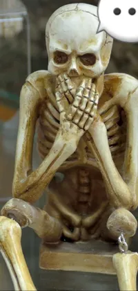 Experience the macabre with this intricate phone live wallpaper featuring a group of skeleton figurines sitting next to each other